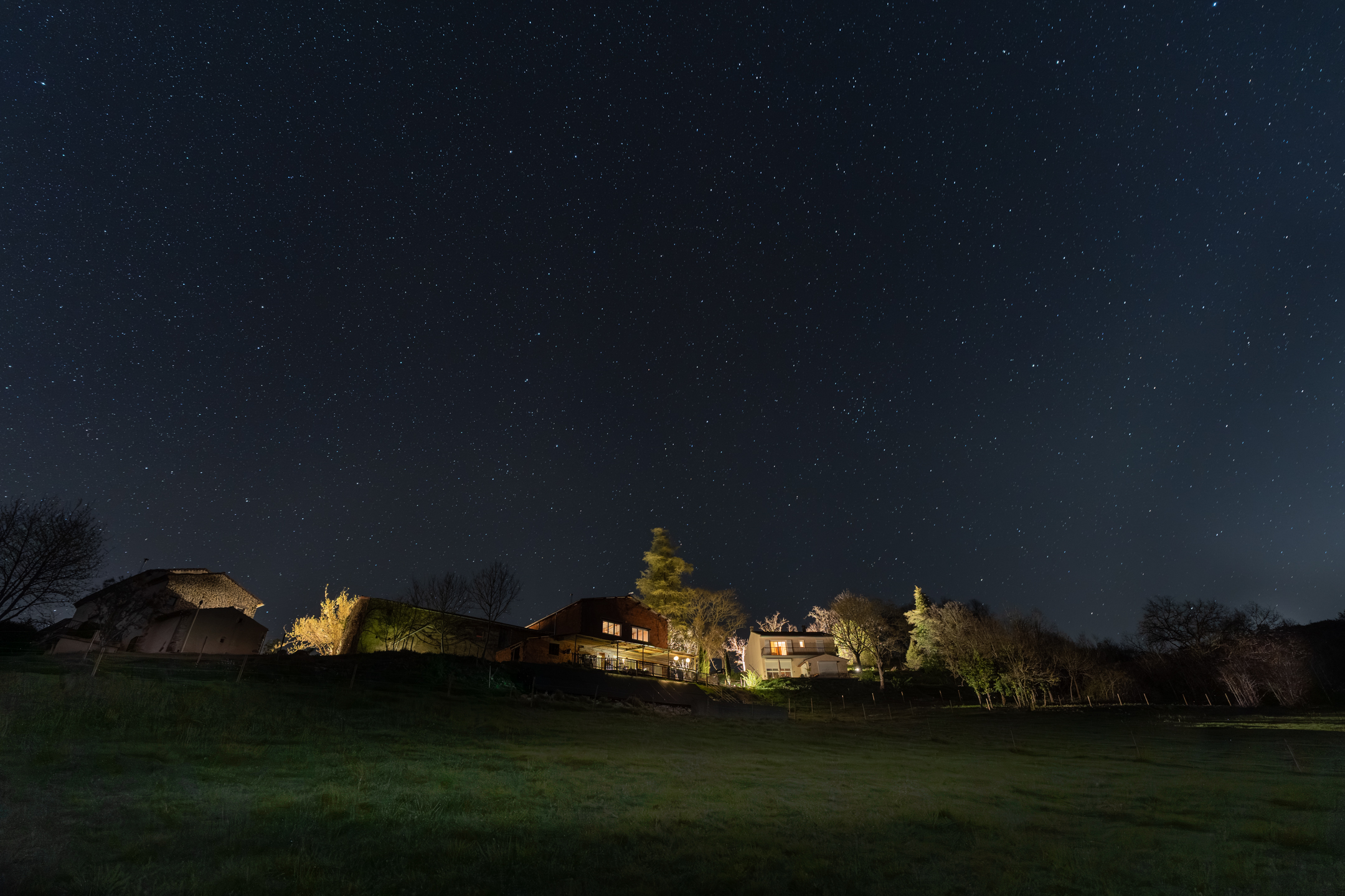 Sternenhimmel über den beleuchteten Häusern von La Bastide in Puycalvel